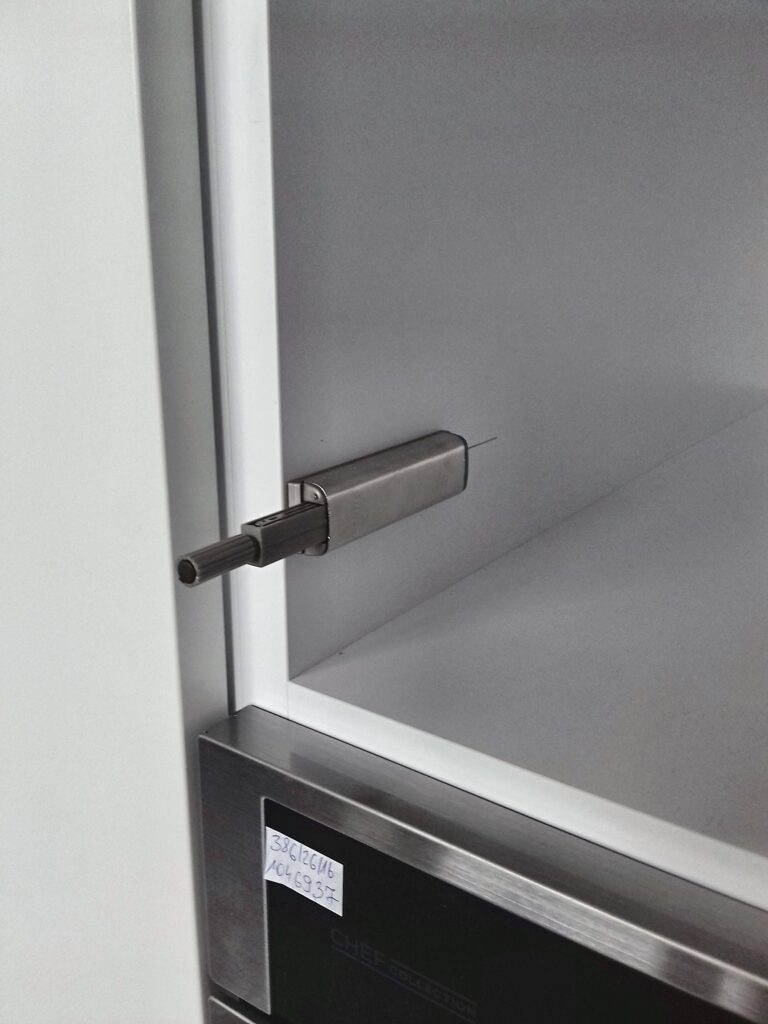Detal zawiasu z cichym domykiem w szafce kuchni na wymiar w Warszawie